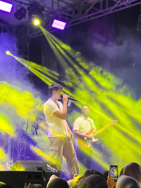Ekhsan singing under stage lights